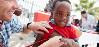 Shot of a volunteer doctor giving checkups to underprivileged kids