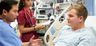 Male Patient Talking To Medical Staff In Emergency Room
