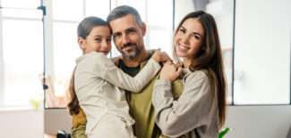 Happy masculine man smiling and hugging his family