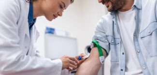 Nurse pierces the patient's arm vein with needle blank tube.