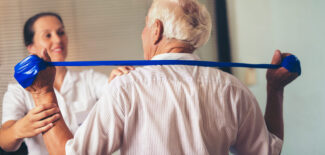 Senior man doing exercises using a strap to extend