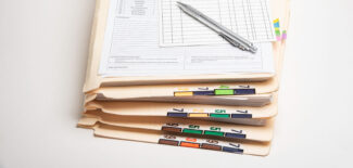 A stack of color-coded and numbered patient medical records